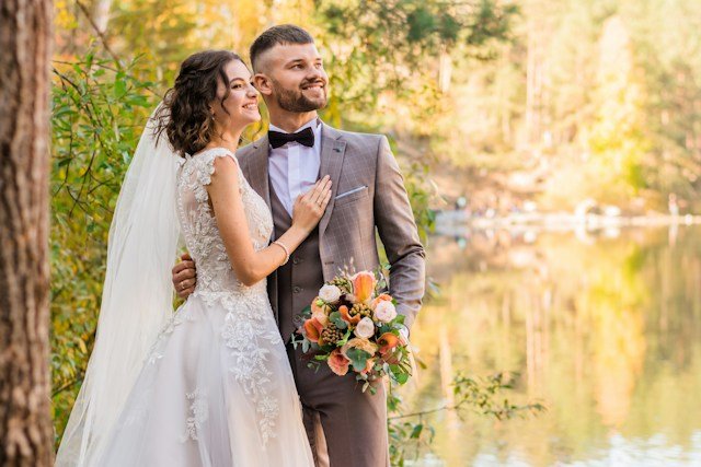 Meera and Aarav by a lake, she in a veil with a bouquet